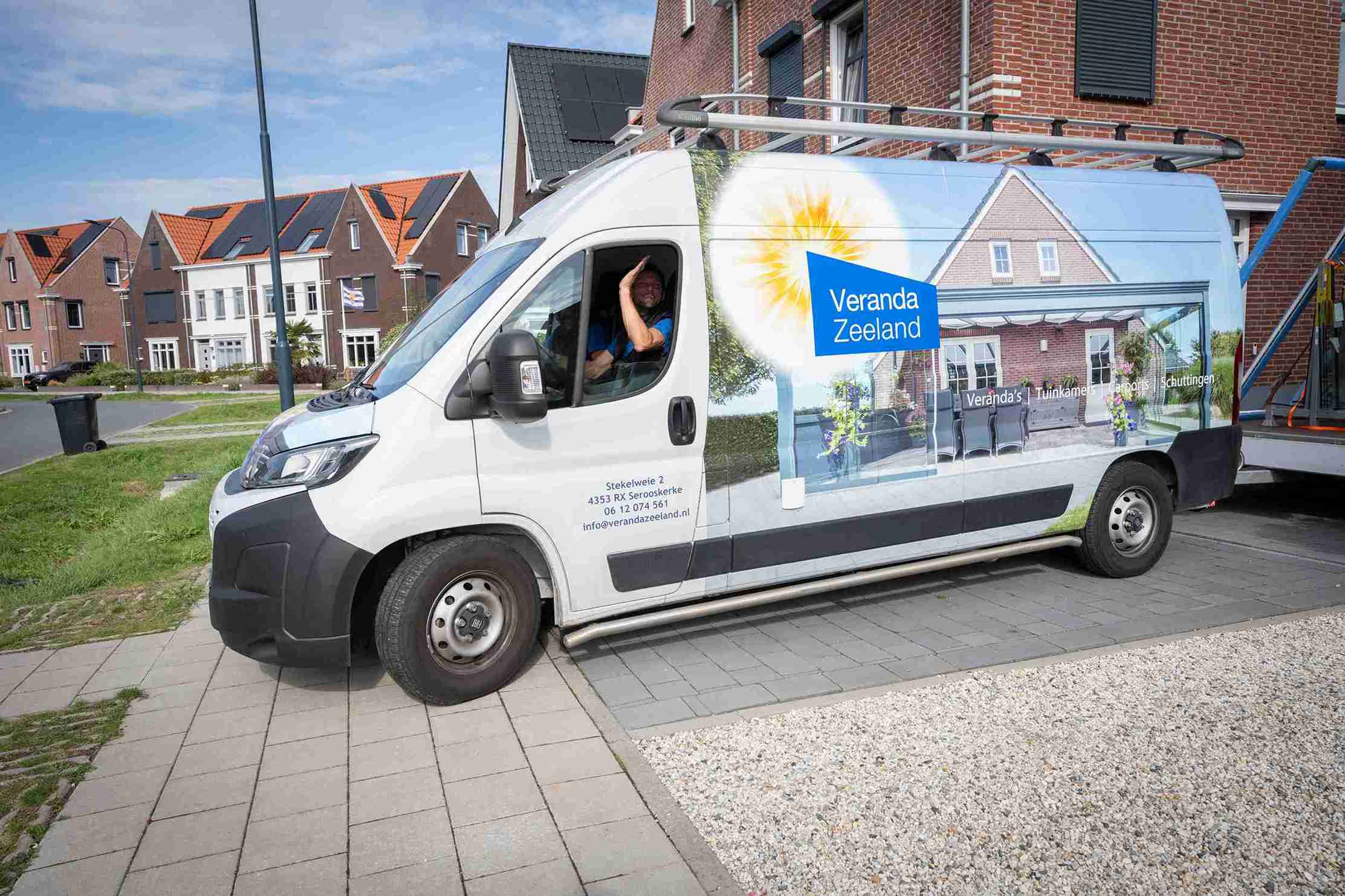 Bedrijfsbus van Veranda Zeeland met monteurs die wegrijden, nadat ze een veranda hebben gemonteerd